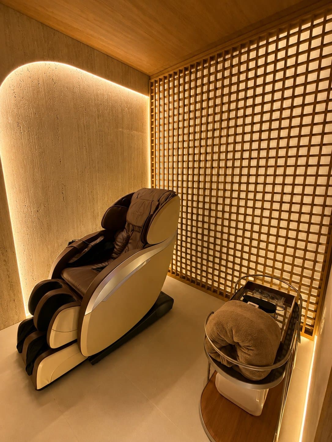 Sala Montevidéu: poltrona de relaxamento diante da parede quadriculada de madeira iluminada